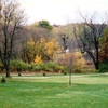 A fall view of green with narrow path in background at Highland Hills Golf Club