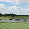 A view of a green with a bridge in the background at Holly Meadows Golf Course