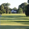 View of a green with clubhouse in the back at The Fields Golf Course