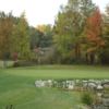 A fall view of a green guarded by a pond at Prairie Creek Golf Course