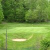 A view of a green protected by a bunker at Fox Run Country Club