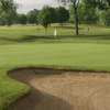 A view of a green protected by a bunker at Glenhurst Golf Course