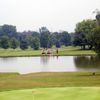 A view of green surrounded by water with two carts in  background at Reddeman Farms Golf Club