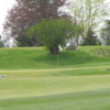 A view of green with one cart in background at Sugarbush Golf Club