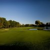 View of the 18th green surrounded by water at Cherry Creek Golf Club