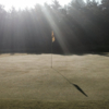 A sunny day view of a hole at Alpine Meadows Golf Course