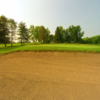 A view of a green protected by a large bunker at Willow Brook Golf Club